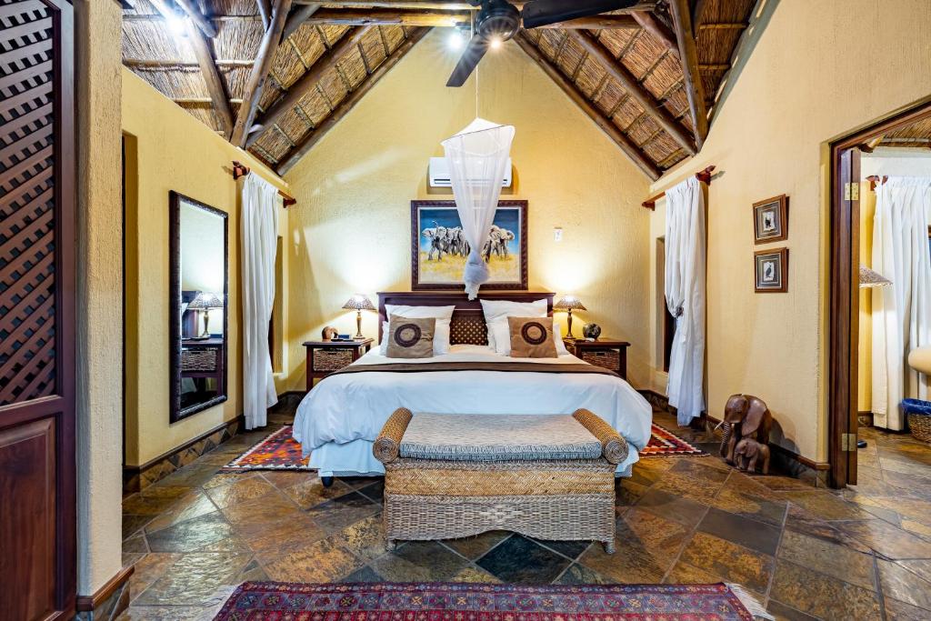 ein Schlafzimmer mit einem großen Bett in einem Zimmer in der Unterkunft Mhlati Guest Cottages in Malelane