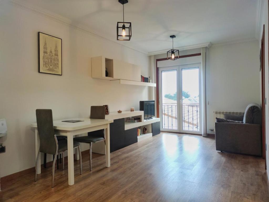 Il comprend une cuisine et un salon avec une table et des chaises. dans l'établissement Desconectaengalicia Isla Arosa con vistas al mar, à L'île d'Arousa