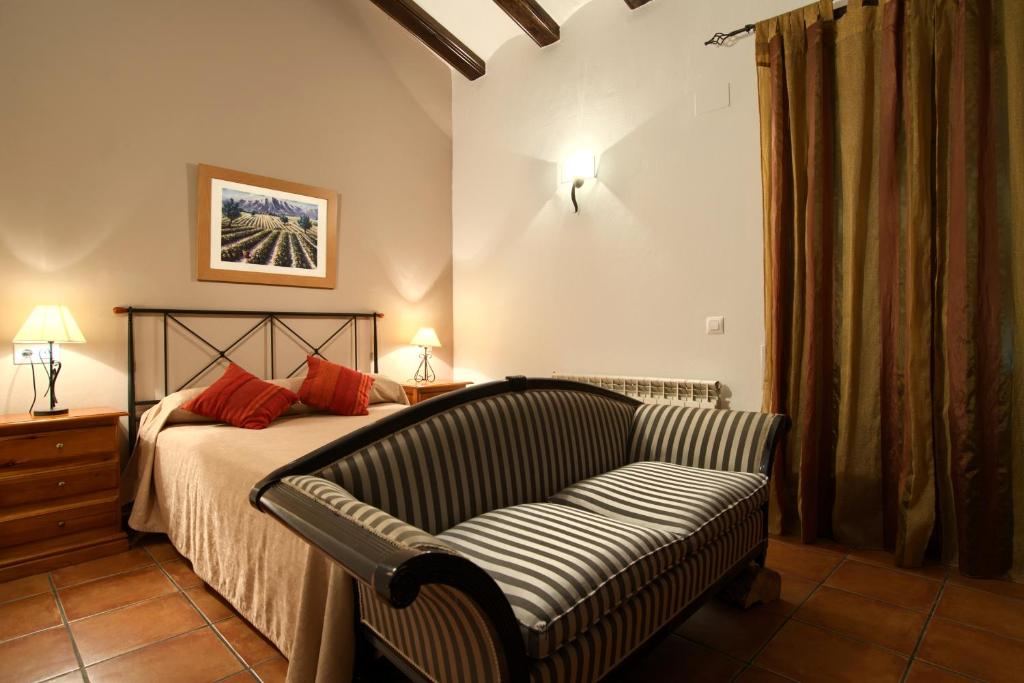 1 dormitorio con 1 cama con sofá y silla en Casa Rural El Olmo, en Gúdar