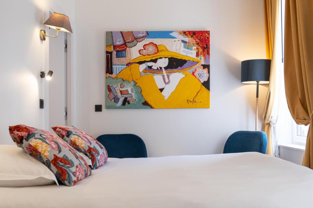 a bedroom with a bed with a painting on the wall at Boutique Hotel Nice Côte d'azur in Nice