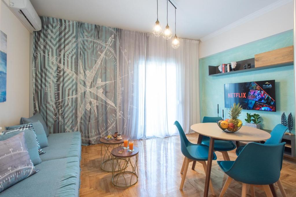 a living room with a blue couch and a table at Blue Ark Wanderlust in Athens