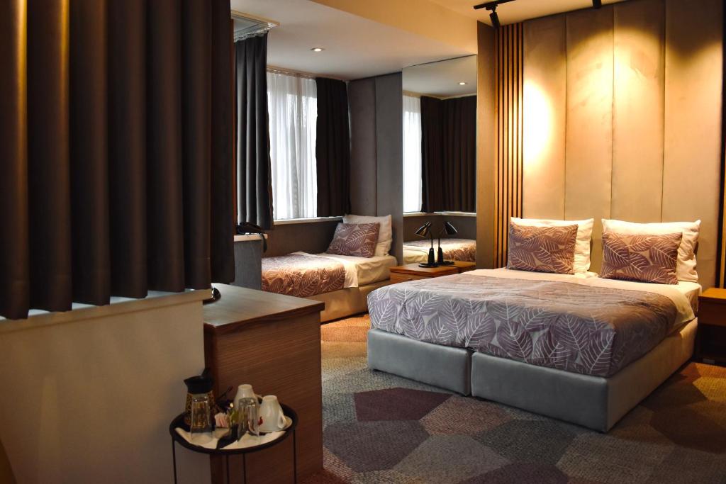 Hotel City View Deluxe في سراييفو: غرفه فندقيه بسرير واريكه