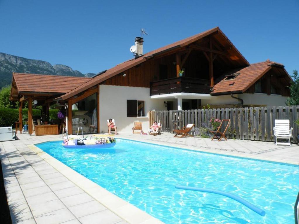 - une piscine en face d'une maison dans l'établissement Gîte Annecy 06 - Au Royaume des Marmottes - Appt 06, à Doussard