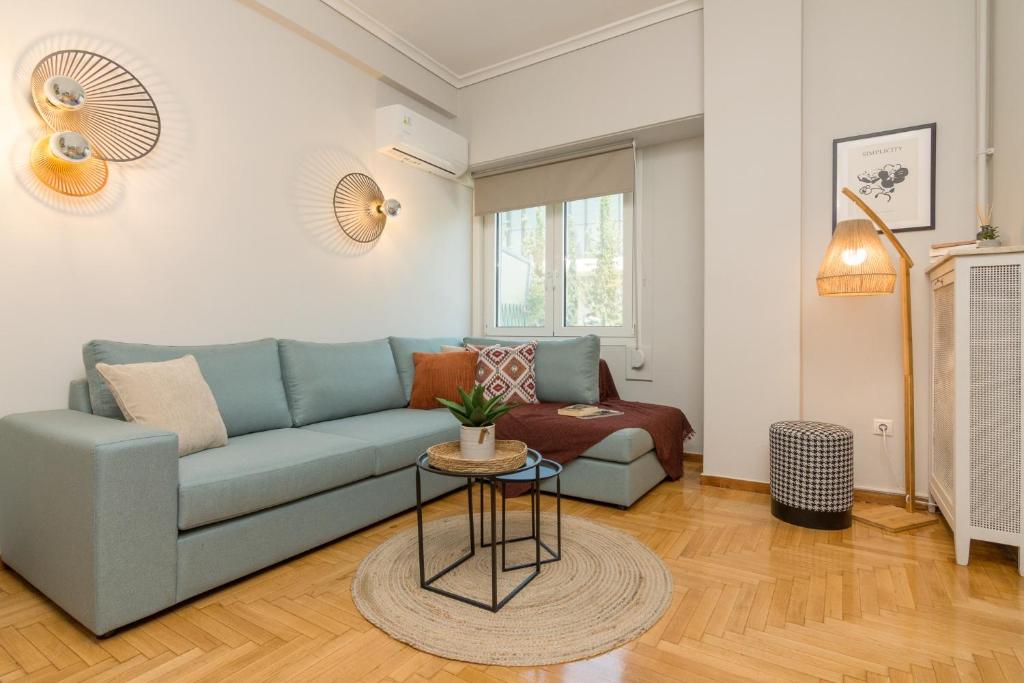 a living room with a blue couch and a table at Spacious 2 Bedroom Apartment In Koukaki in Athens