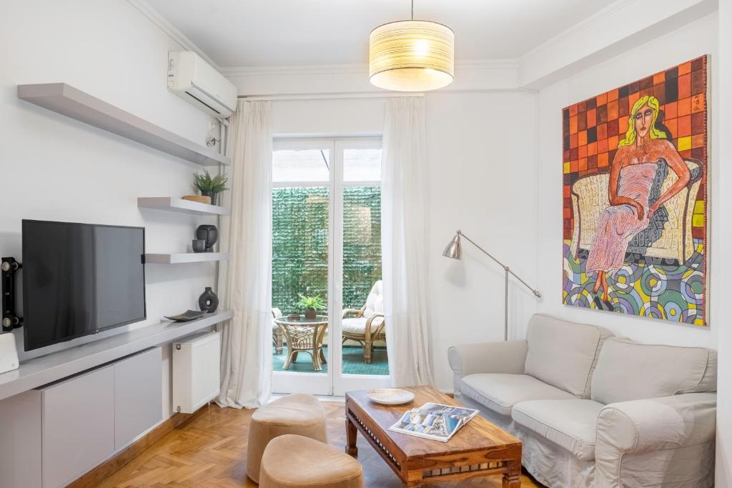uma sala de estar com um sofá e uma televisão em Central Athenian 1BR Apartment em Atenas