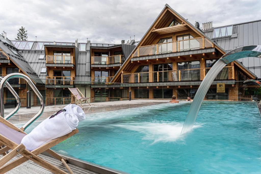 a pool with a water slide in front of a building at Apartamenty Royal Resort & Spa in Zakopane