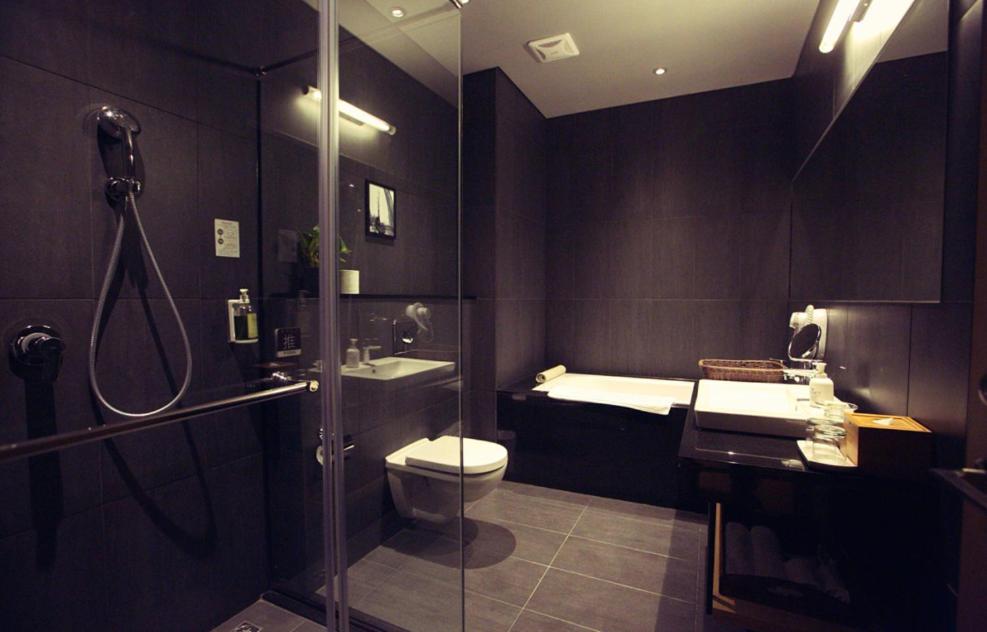 a bathroom with a shower and a toilet and a sink at Chiayi Guanzhi Hotel in Chiayi City