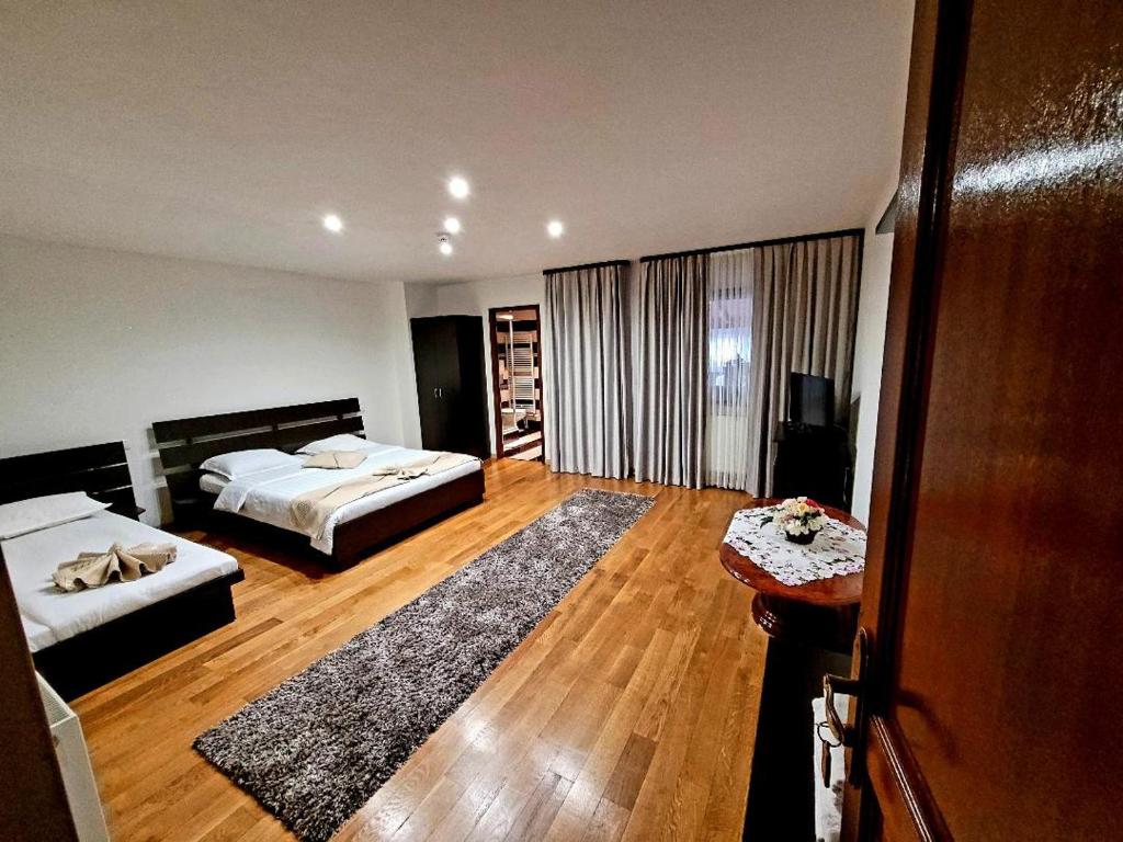 een slaapkamer met 2 bedden en een houten vloer bij ECO-TIM in Moisei