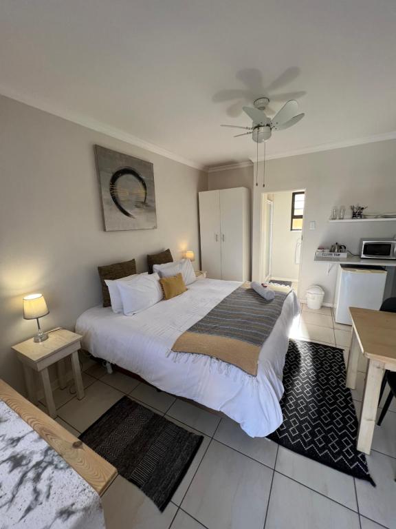 a bedroom with a large white bed and a table at 10 on Beresford in East London