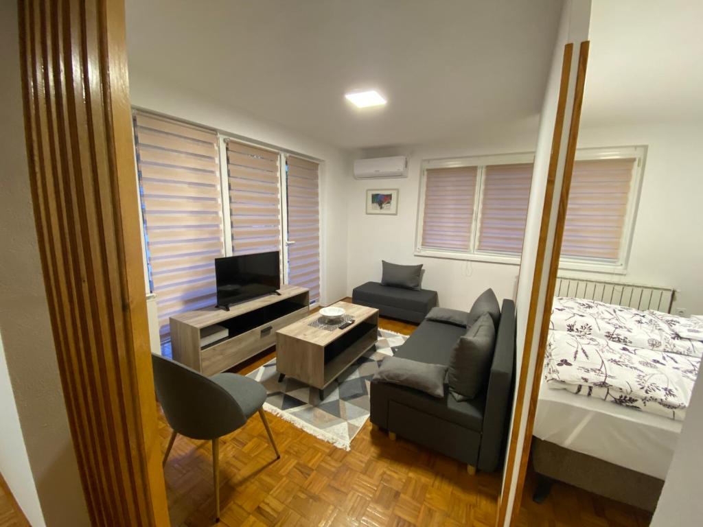 ein Wohnzimmer mit einem Bett, einem Sofa und einem TV in der Unterkunft Happy holiday in Visoko