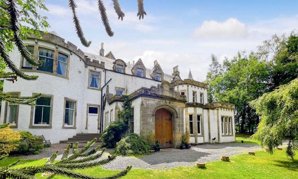 an old house with a door in a yard at Harvieston Hall in Gorebridge