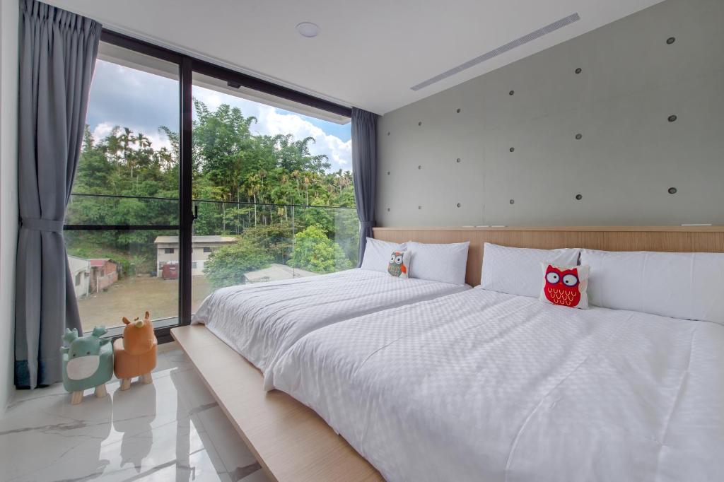 a bedroom with a large bed with two owls on it at 奈斯窩客 l 湖景房 l 含早餐 in Shui-wei