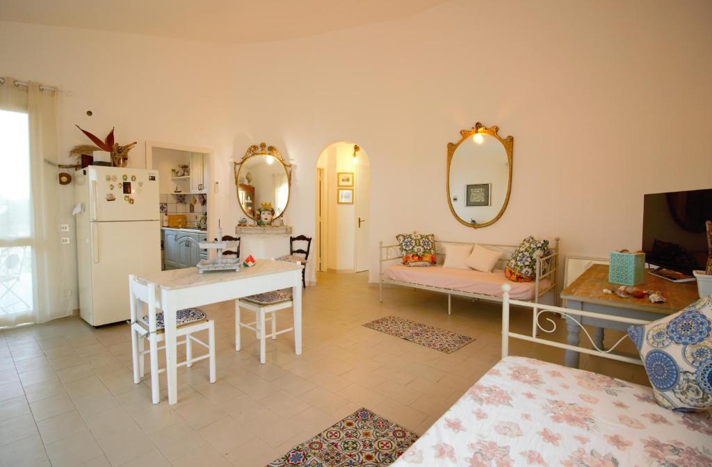 a living room with a table and a couch and a kitchen at Villa Beatrice 25 in Siracusa
