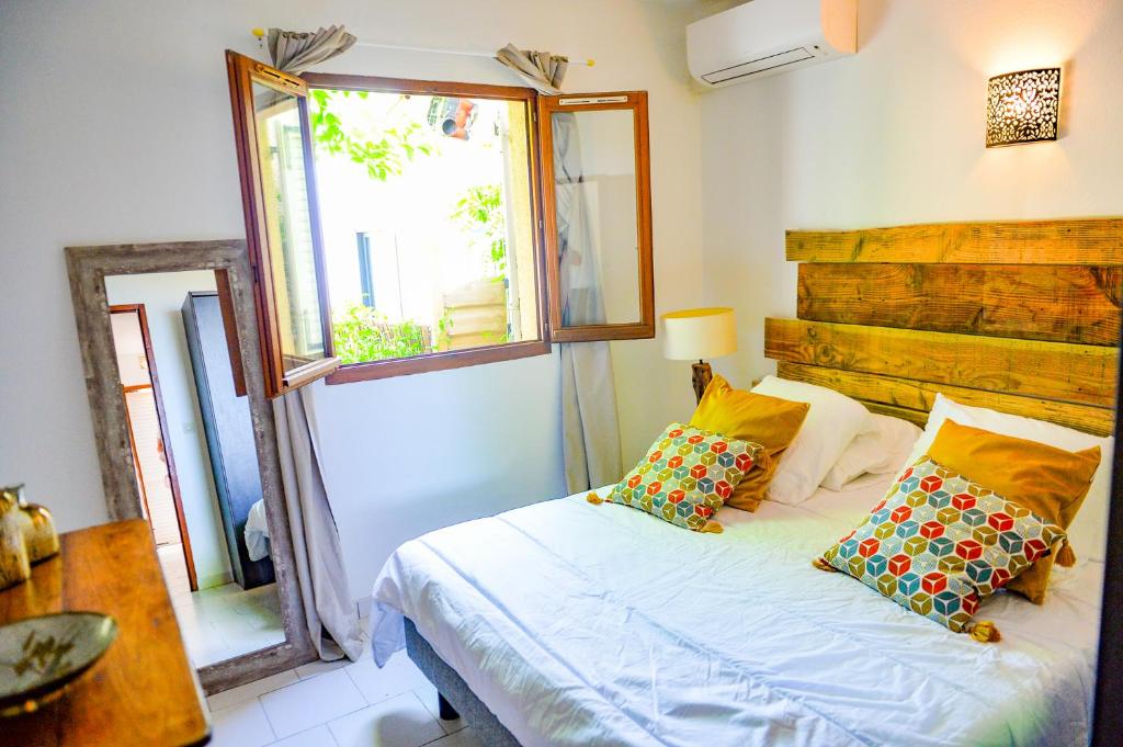 Schlafzimmer mit einem Bett und einem Fenster in der Unterkunft Sandra - Maison, Patio, Plage d'argent à 2 min - Verghia in Coti-Chiavari