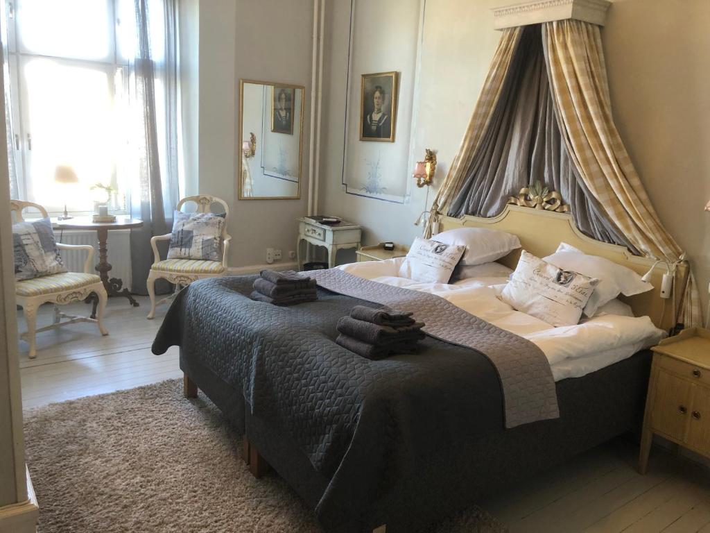- une chambre avec un grand lit à baldaquin dans l'établissement Strand Hotel, à Norrköping