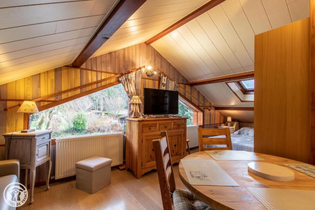 jadalnia ze stołem i telewizorem w obiekcie Gîte Annecy 07 - Au Royaume des Marmottes - Appt 07 w mieście Doussard