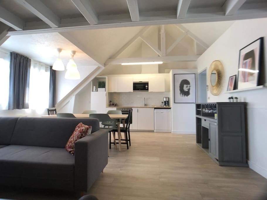 sala de estar y cocina con sofá y mesa en Angers - L’appartement de Marius, calme et confort, en Angers