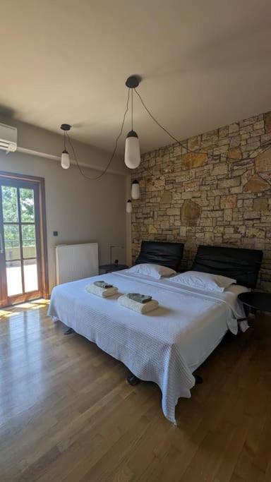 a bedroom with a large bed with a stone wall at Villa Khaki 