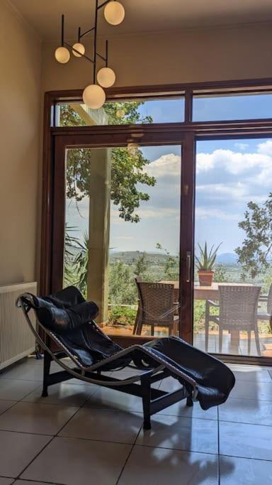 a room with a chair in front of a large window at Villa Khaki 