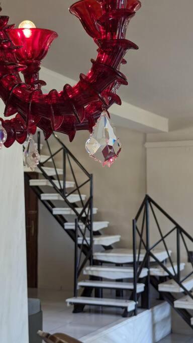 a staircase with red chandeliers hanging from the ceiling at Villa Khaki 