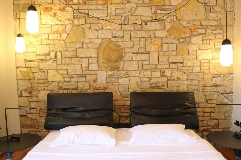a bed in front of a stone wall at Villa Khaki 