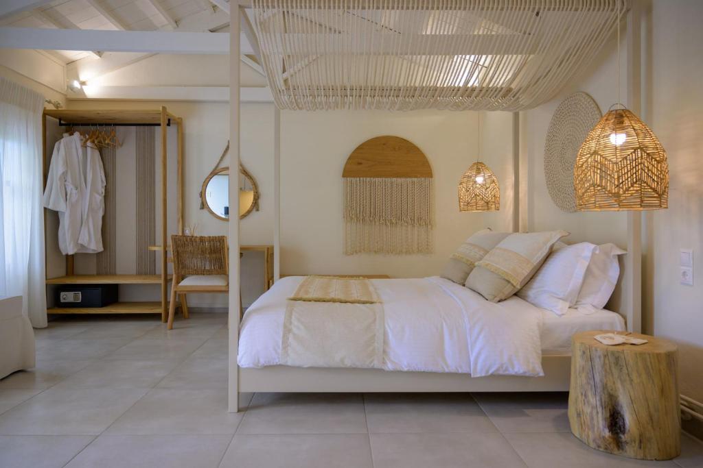 a bedroom with a white bed with a tree stump in it at Oikies Small Elegant Houses in Mytilini