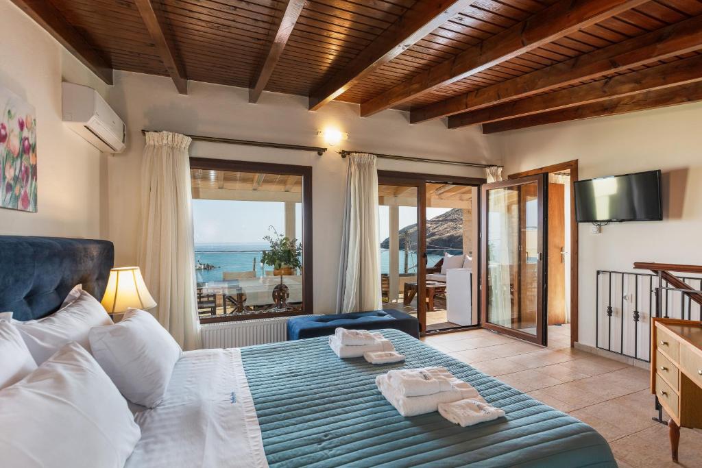 sypialnia z łóżkiem i widokiem na ocean w obiekcie Penelope Home w mieście Panormos