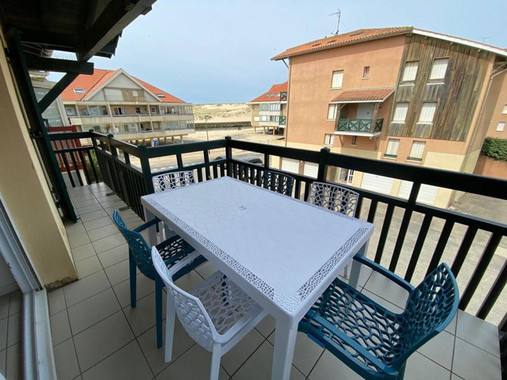 d'une table et de chaises blanches sur un balcon. dans l'établissement Appartement Vieux-Boucau-les-Bains, 3 pièces, 6 personnes - FR-1-379-75, à Vieux-Boucau-les-Bains