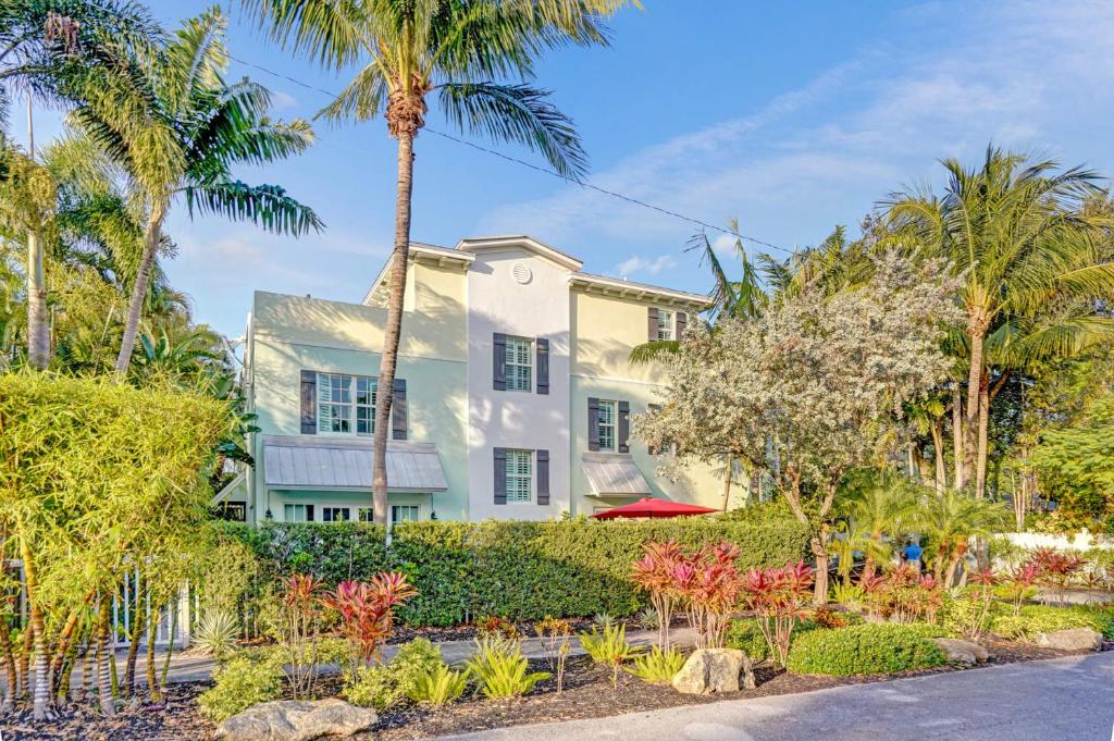 een wit huis met palmbomen en een tuin bij Fabulous 4BR home close to beach in Fort Lauderdale