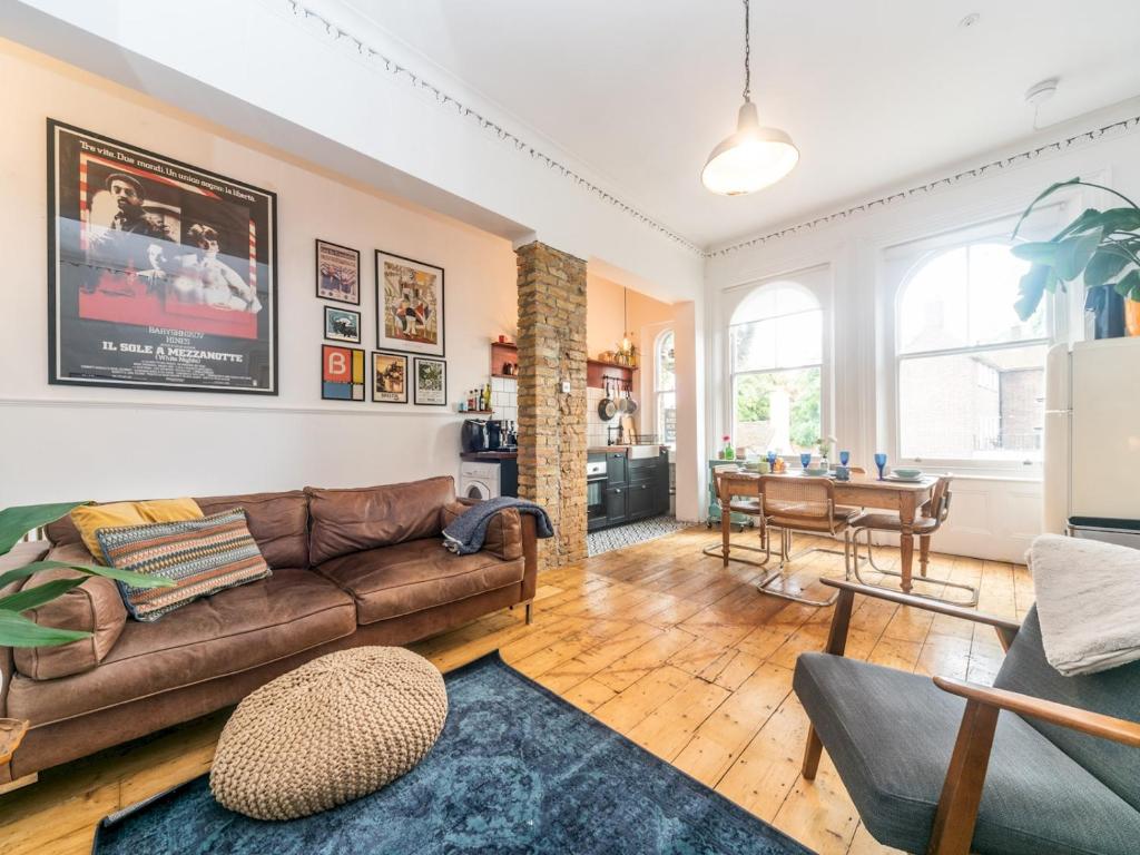 uma sala de estar com um sofá e uma mesa em Pass the Keys Rustic and Quirky Flat in Charming Charlton Village em Londres