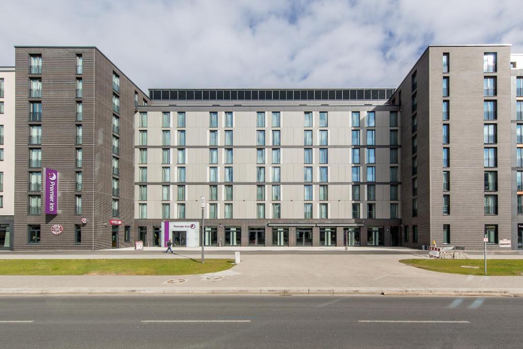 un grand bâtiment blanc avec une rue en face dans l'établissement Premier Inn Frankfurt Messe, à Francfort-sur-le-Main