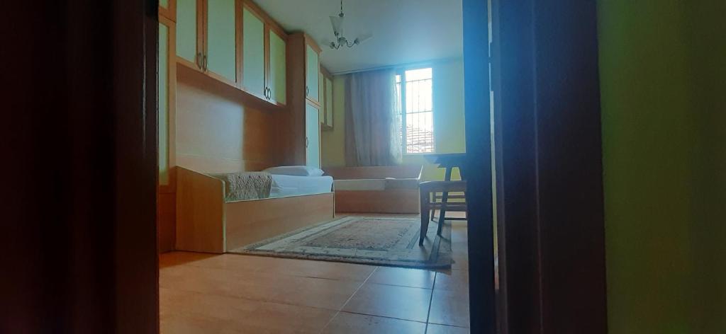 um quarto com uma cama, uma mesa e uma janela em Enki's Guesthouse em Tirana