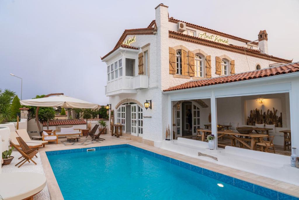 a house with a swimming pool in front of a house at Anıt Konak in Alaçatı