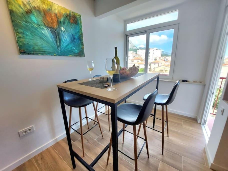 a dining room table with four chairs and a painting at Orla Beach Apartment in Makarska