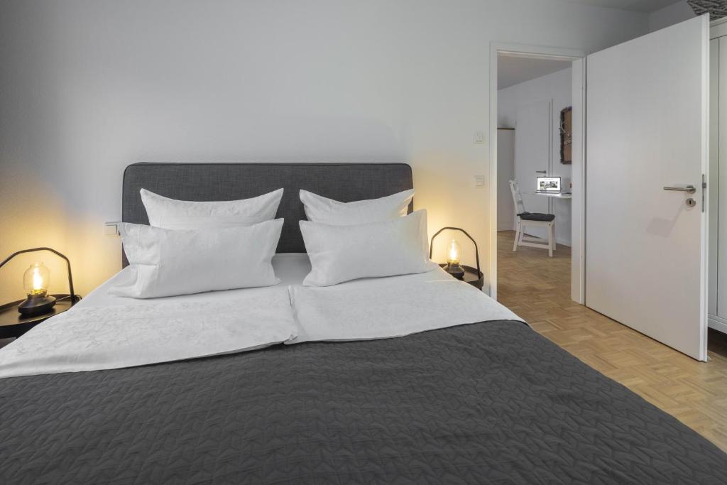 a bedroom with a large bed with white pillows at Acapella Suite Barcarolle 60qm, direkt am Weinberg, Altstadt, Netflix inklusive in Heppenheim an der Bergstrasse