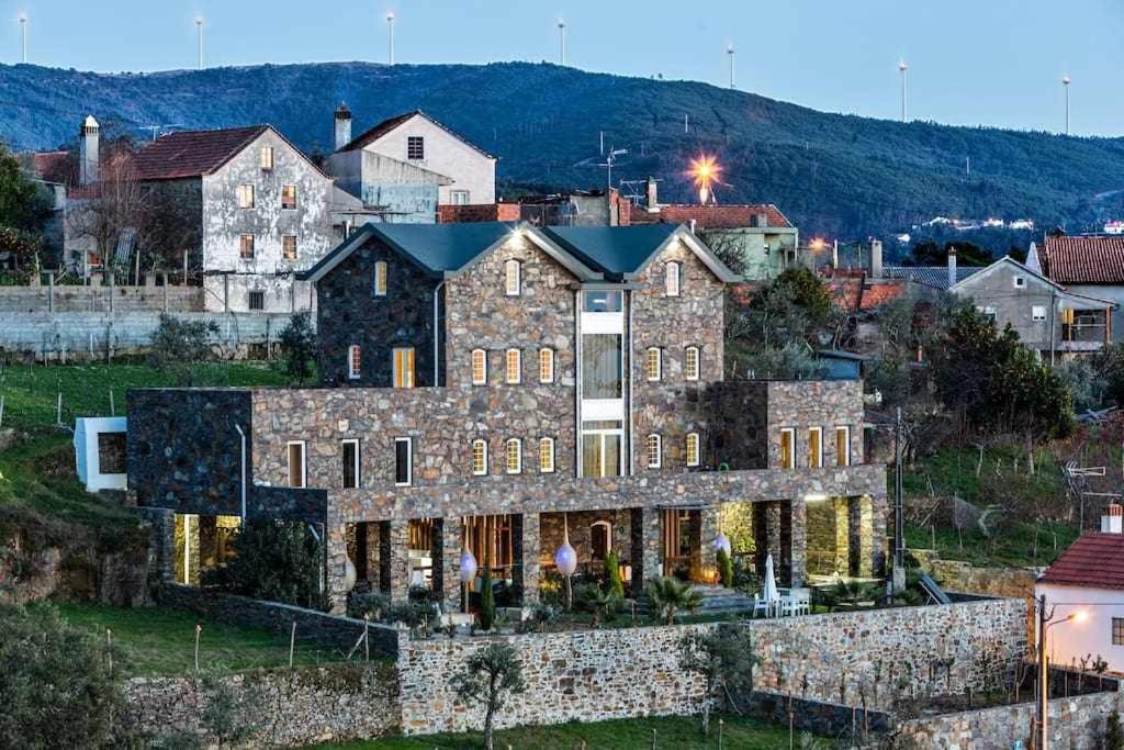 uma grande casa de pedra numa cidade em A Casa do Tio Tenente Casa Toda em Ermida