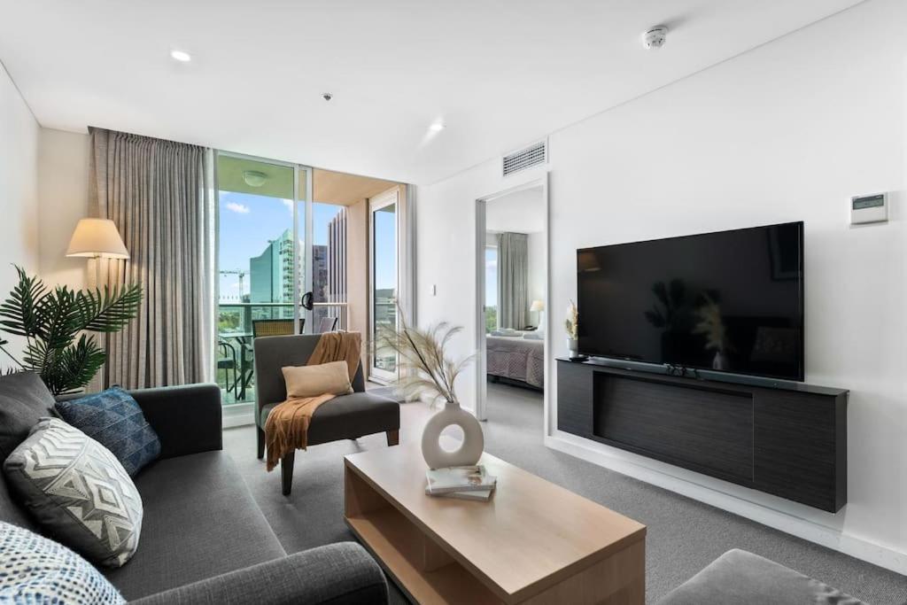 a living room with a large flat screen tv at CBD Modern 2BR Free Parking in Adelaide