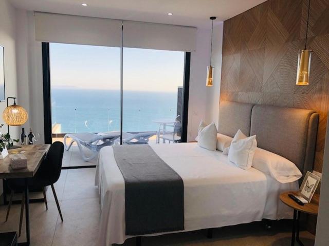 a bedroom with a large bed with a view of the ocean at Villa El Buzo in Zahara de los Atunes