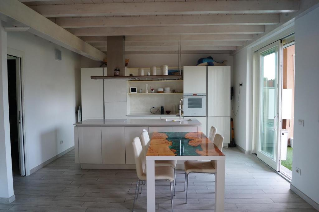 cocina blanca con mesa y sillas en Charme Lake Loft, en Ispra