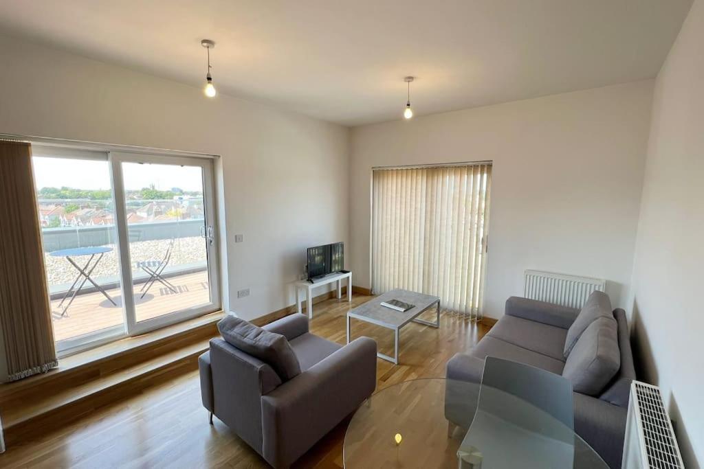 a living room with a couch and a tv at Modern 2 bed flat with balcony in Southend-on-Sea