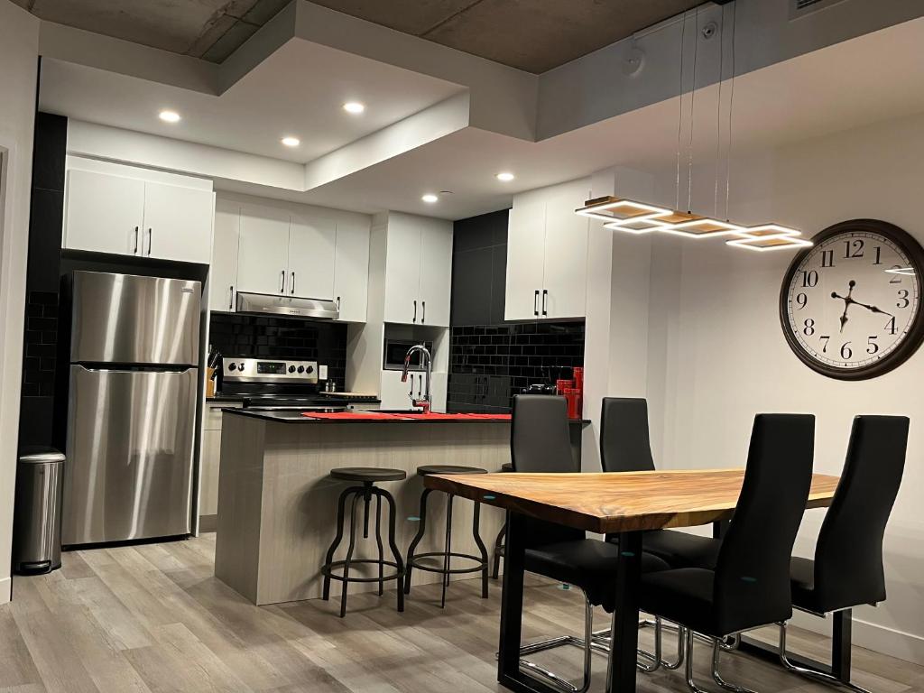 a kitchen with a table and a clock on the wall at Joli condo en basse-ville - Parking gratuit 309357 in Quebec City