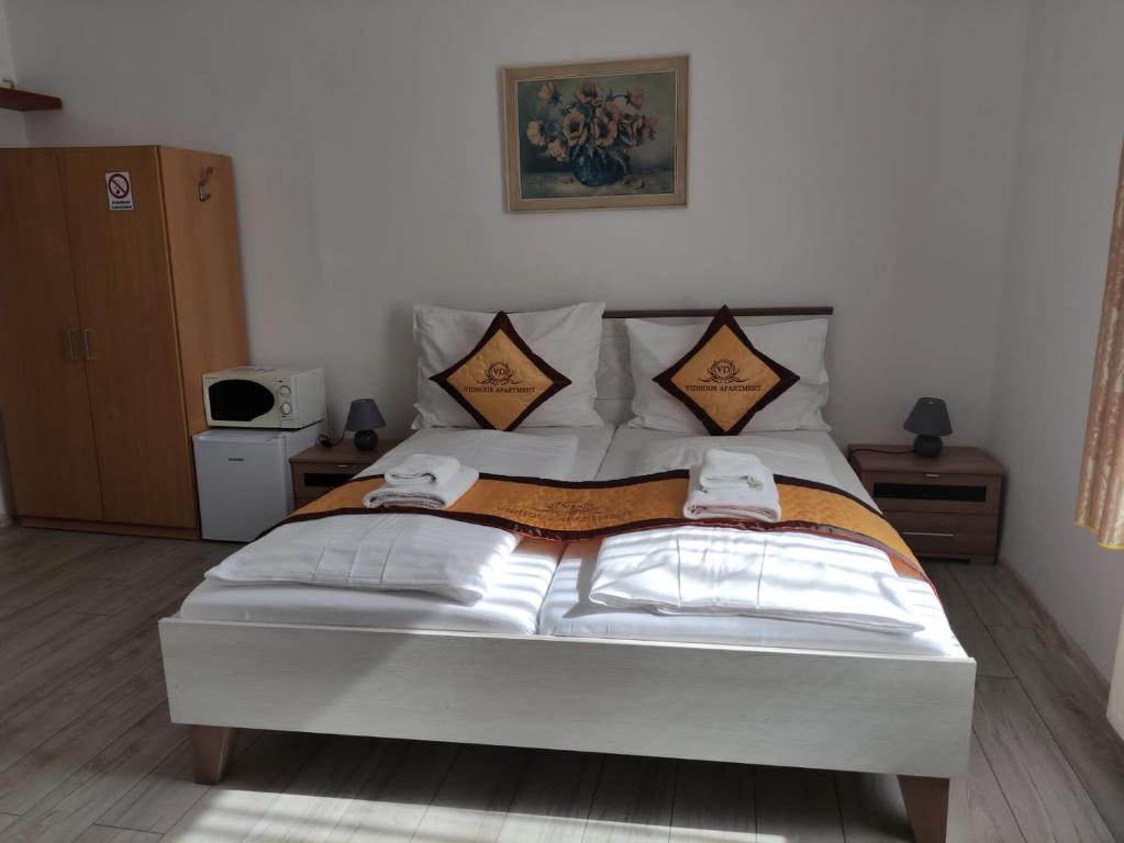a bedroom with a large bed with two pillows at Pension VIDHOUS 1 in Františkovy Lázně