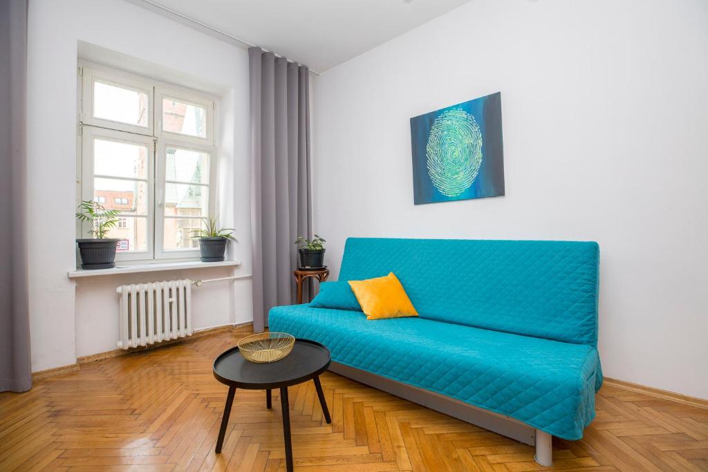 Sofá azul en la sala de estar con mesa en ART Rynek Wrocław en Breslavia