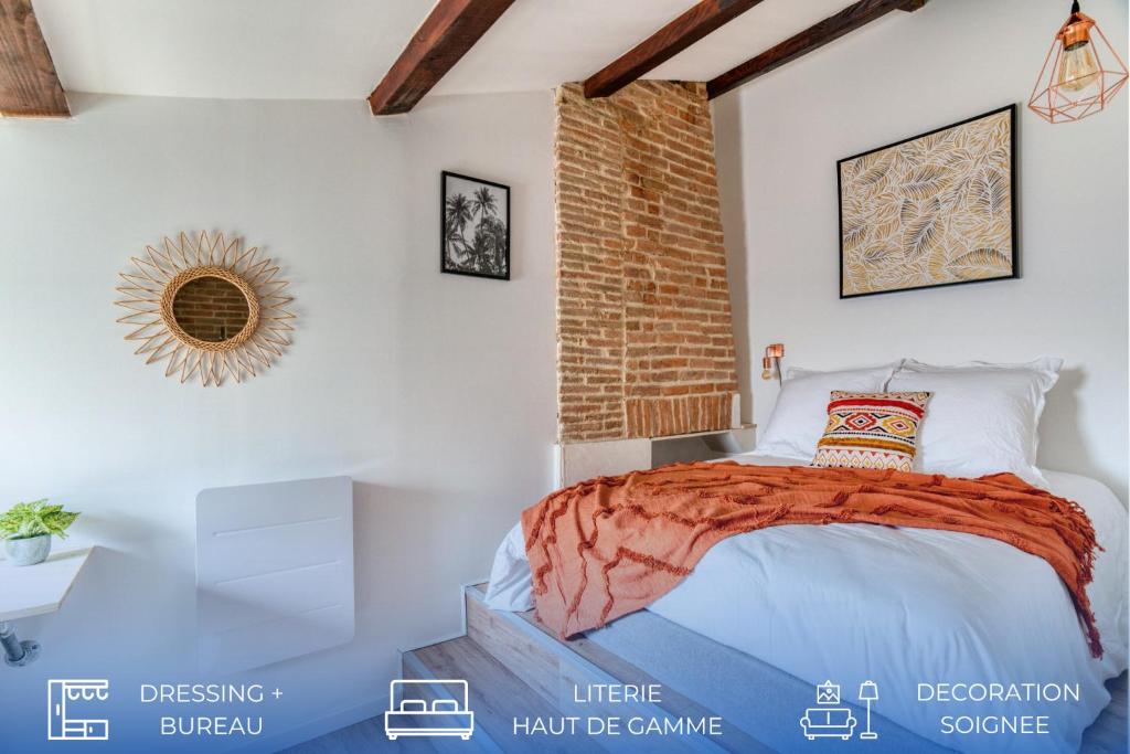 Un dormitorio con una cama y una pared de ladrillo. en Cosy Up - Vieux Port - Hyper Centre, en La Rochelle