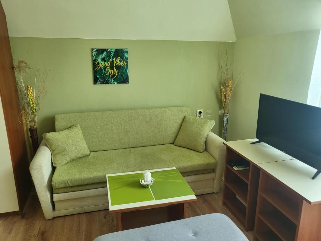 a living room with a couch and a flat screen tv at Penthouse Apartments PERLA, Vasiliko in Tsarevo