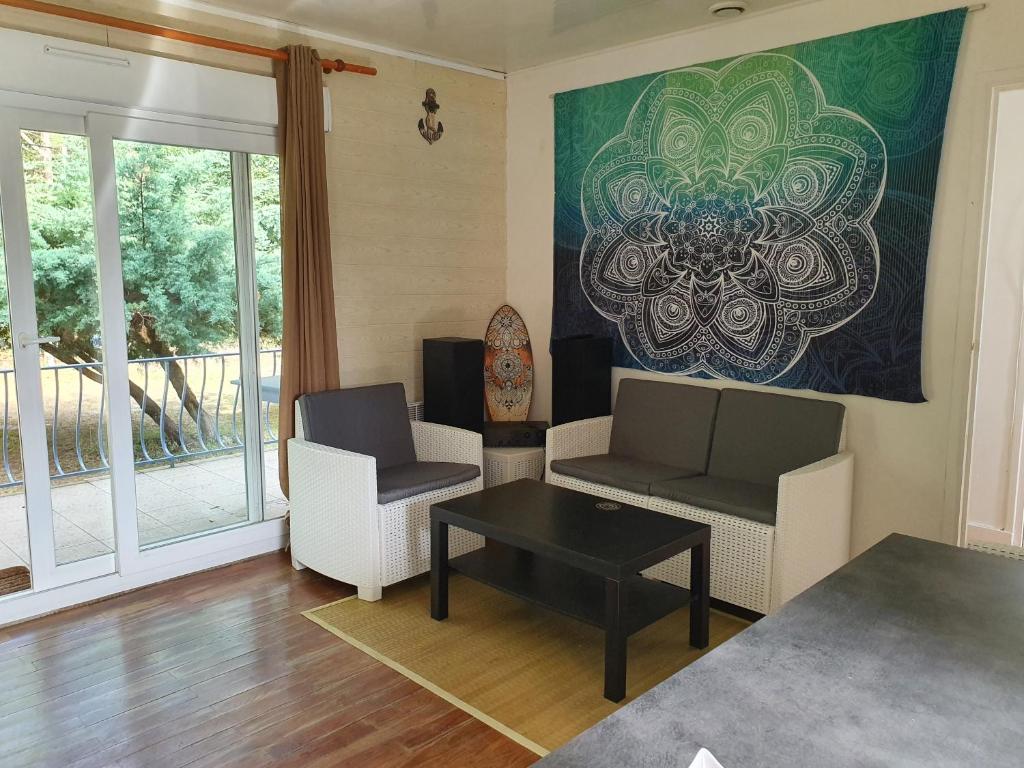 un salon avec deux chaises et une table dans l'établissement Maison proche lacs et océans, à Tosse