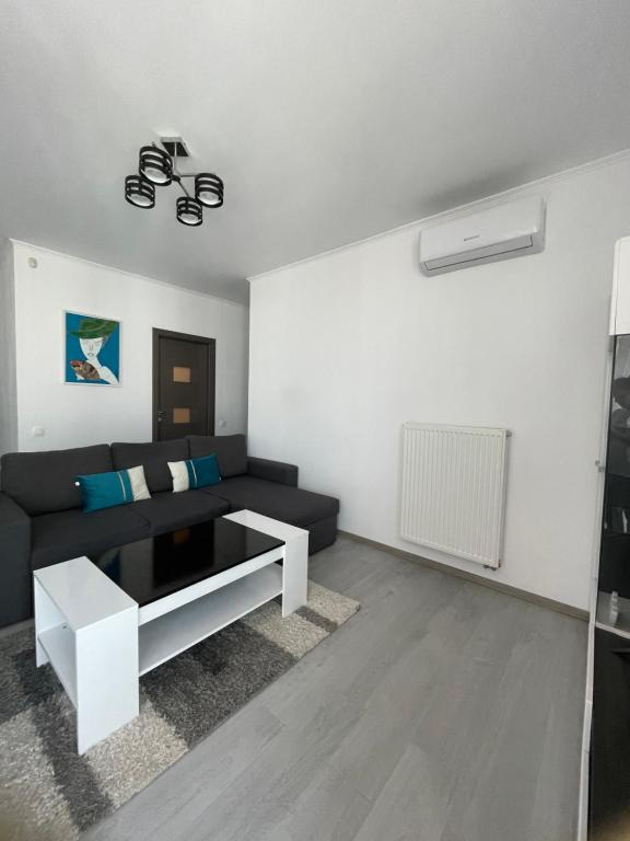 een woonkamer met een bank en een tafel bij Apartament Melanie in Oradea