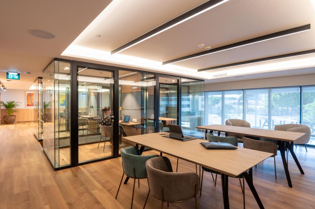 an office with tables and chairs and a laptop on it at Martinhal Lisbon Oriente in Lisbon