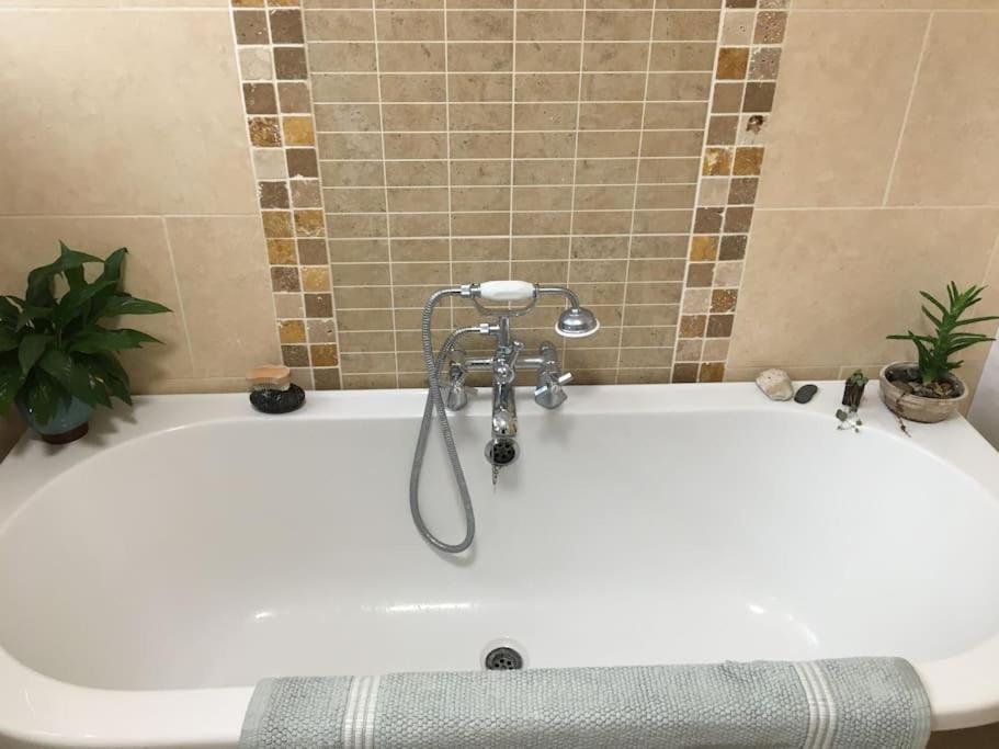 a white bath tub in a bathroom with a plant at Ocean City Apartment-with parking in Plymouth