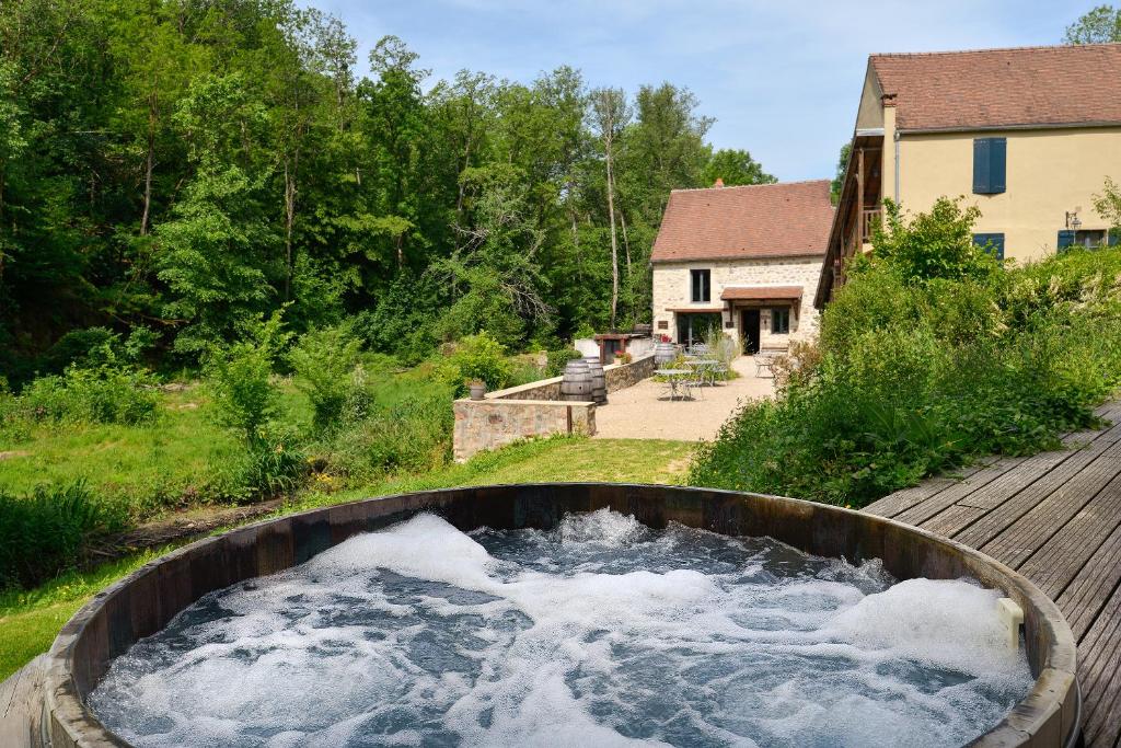 eine große Badewanne mit Wasser im Hof in der Unterkunft Moulin des Templiers Hôtel & SPA in Pontaubert